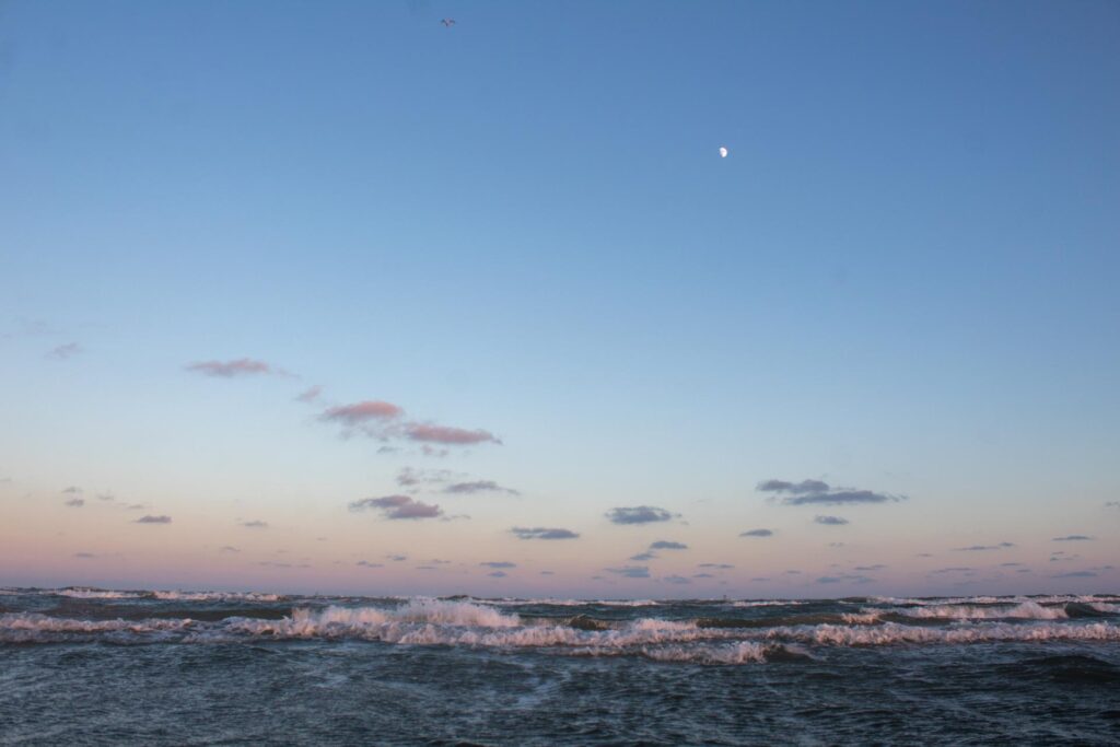 reverse sunset with moon over sea